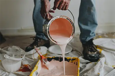 painter pouring paint into a rolling tray