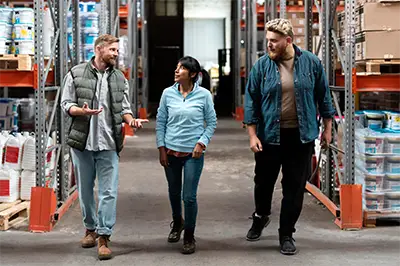 two men and a woman walking through a home improvement store